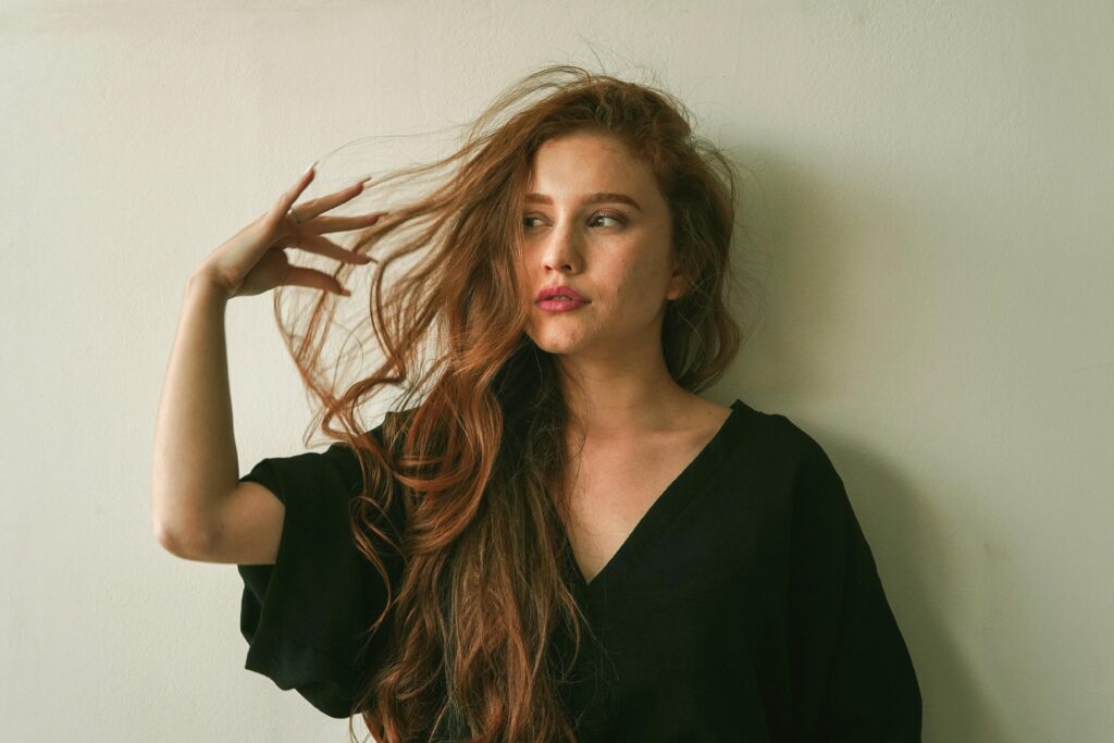 Portrait of a woman with long flowing hair in a relaxed indoor setting.
