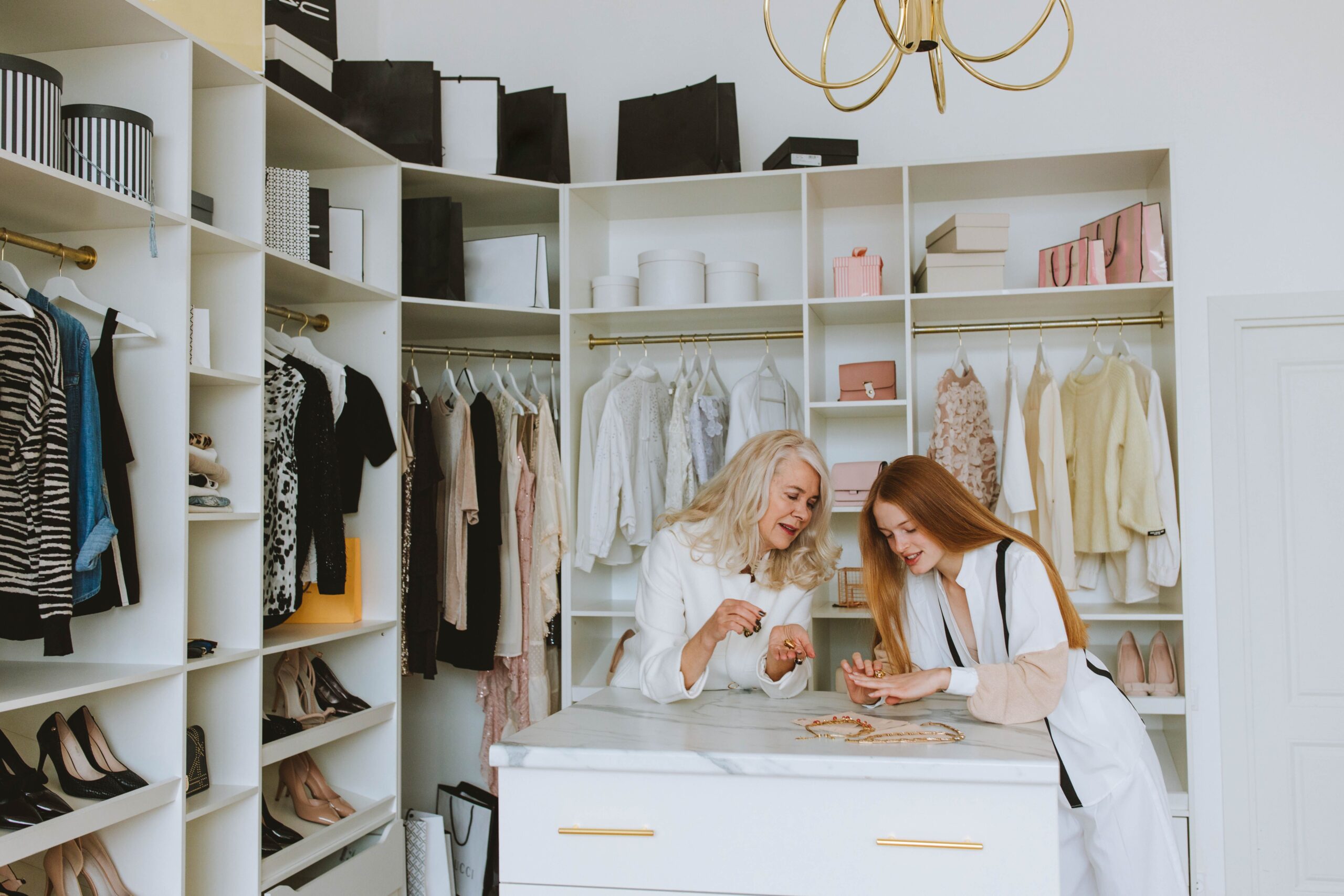 Two women enjoying a luxurious wardrobe setting, showcasing elegance and style.
